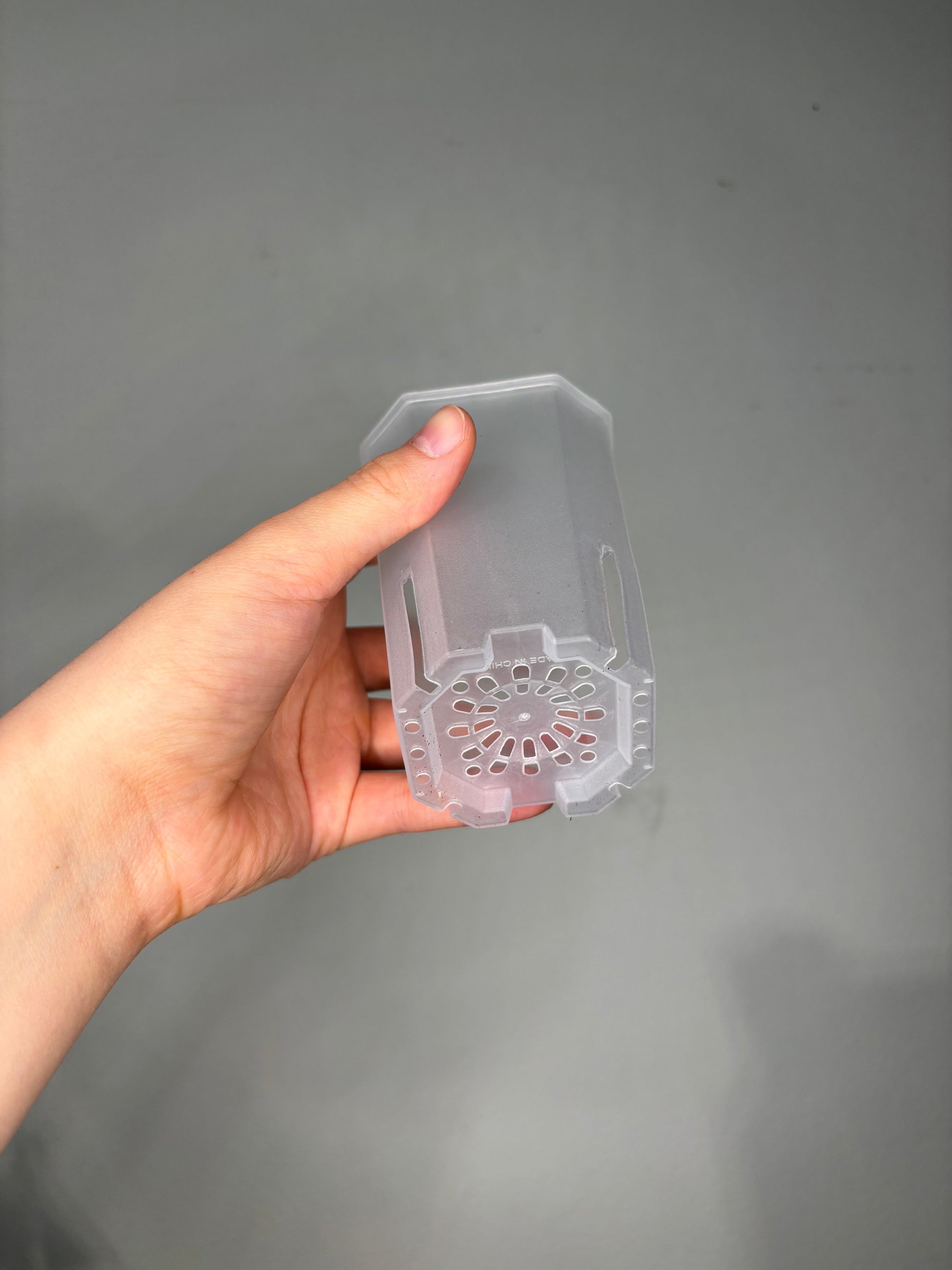 Bottom view of Small Transparent planter pot, 10x8cm, highlighting drainage holes for healthy root aeration in delicate plant species.
