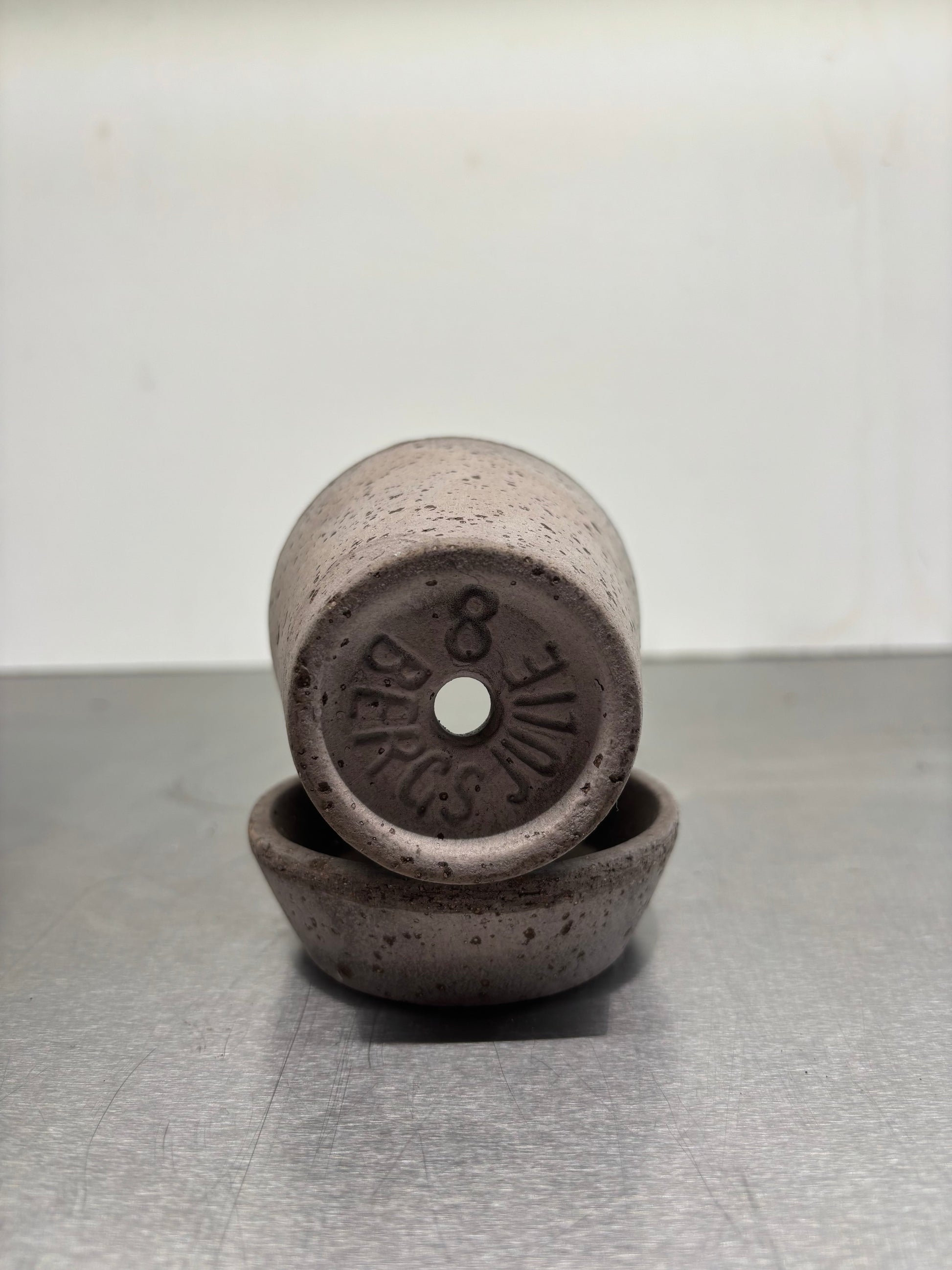 Bottom view of Bergs Clay pots, 9.5x8 cm showing drainage hole and embossed branding, handcrafted in Italy for optimal plant moisture regulation.