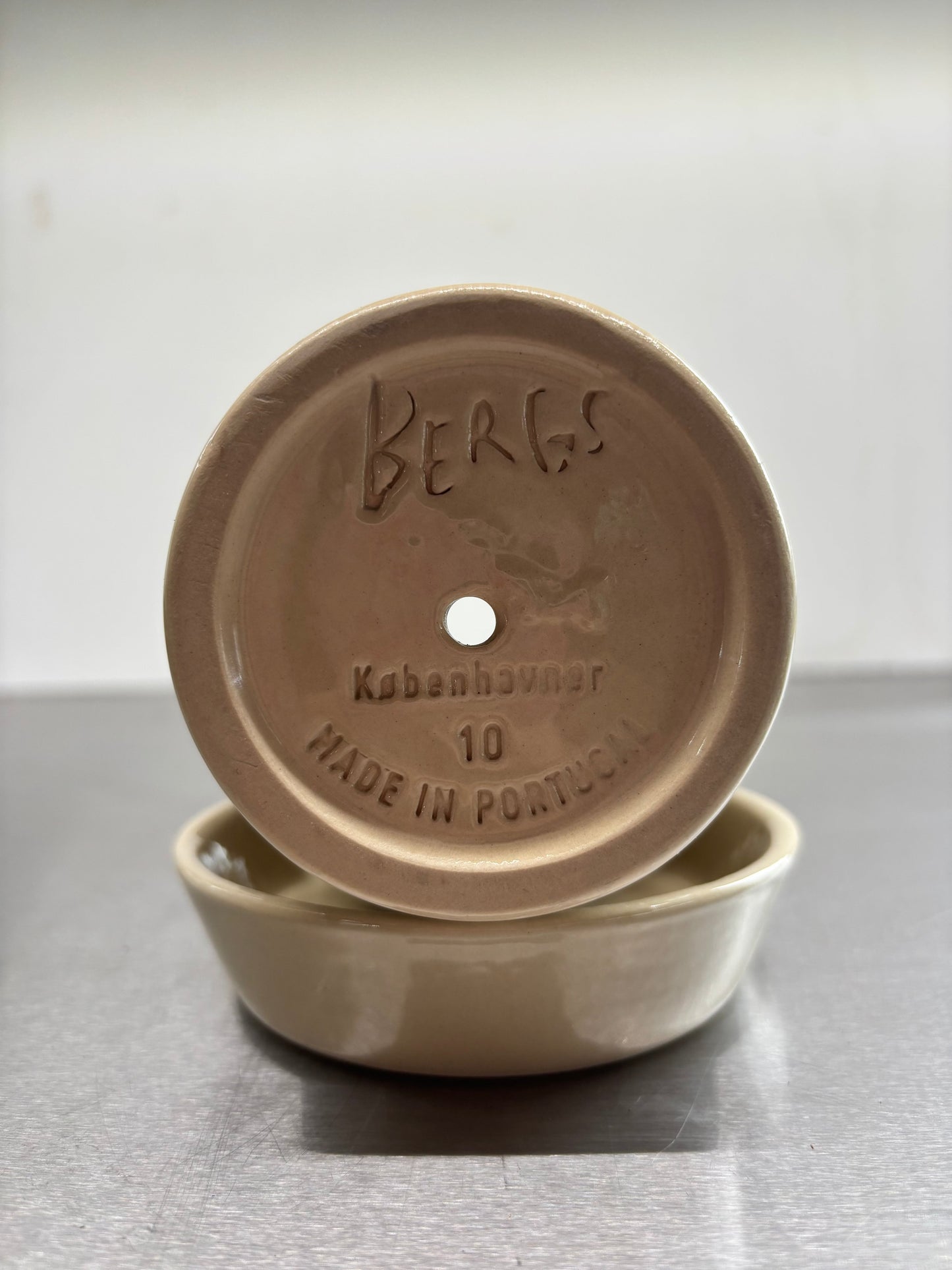 Bottom view of Bergs Ceramic Pots, 10x11 cm, showing drainage hole and embossed branding, handcrafted in Portugal for healthy root growth.