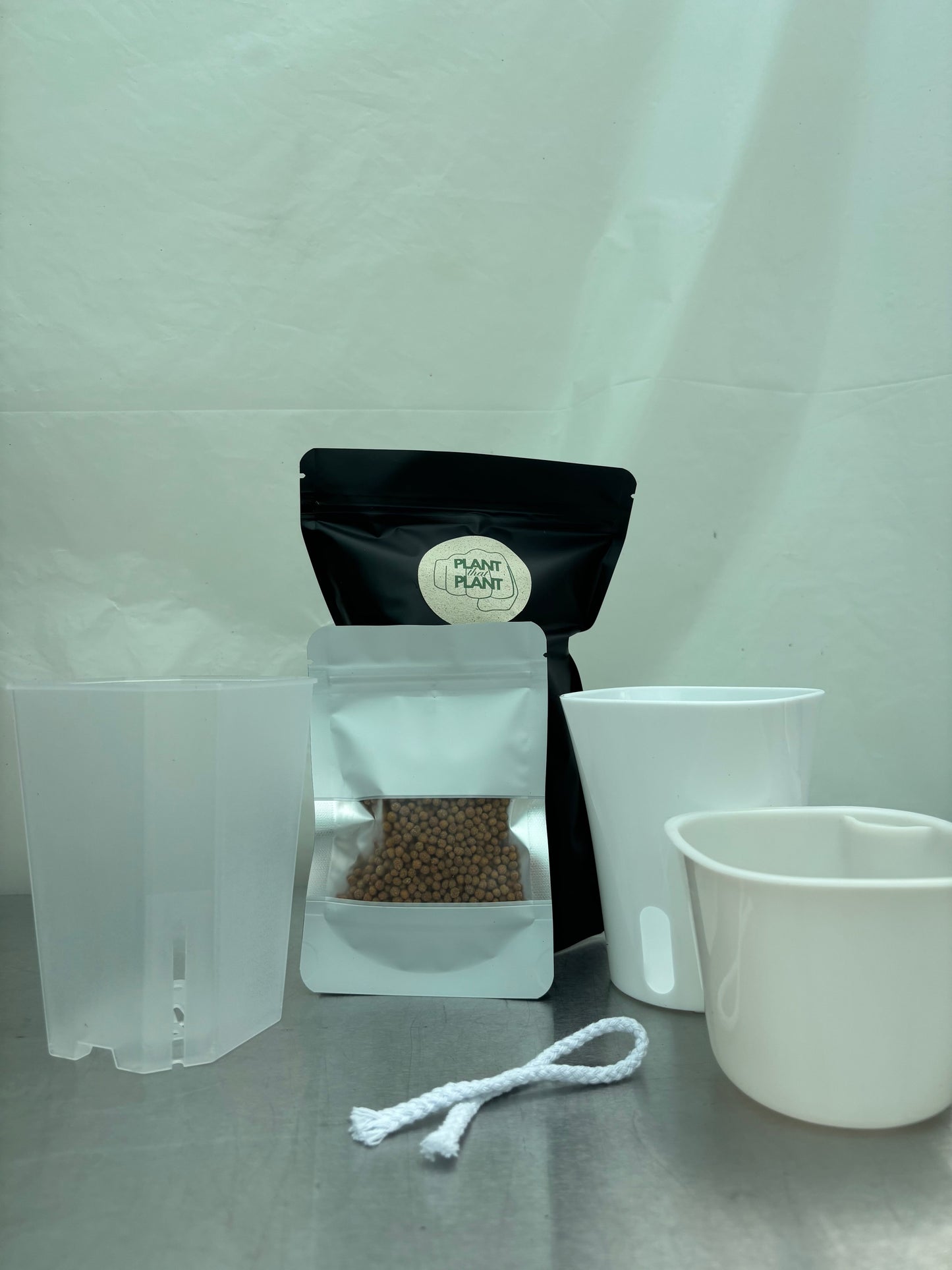 New plant parent starter kit with self-watering planter, transparent pot, clay pebbles, and wick rope for easy plant care. Ideal for beginners.