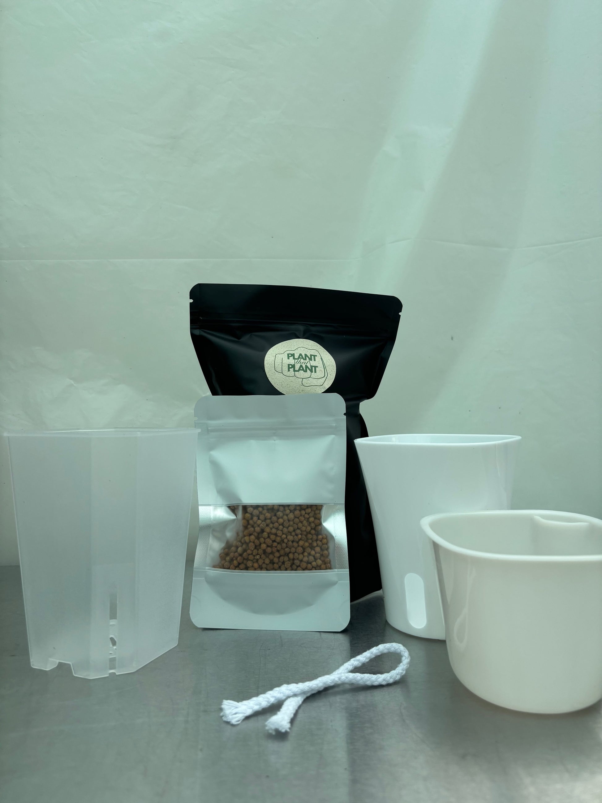 New plant parent starter kit with self-watering planter, transparent pot, clay pebbles, and wick rope for easy plant care. Ideal for beginners.